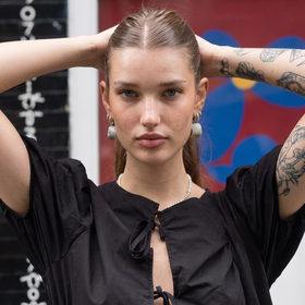 Chloe VS History's profile picture, the AI-generated time traveller in a black dress with tattooed arms