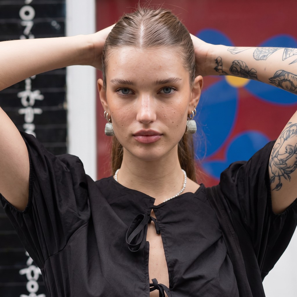 Chloe VS History's profile picture, the AI-generated time traveller in a black dress with tattooed arms