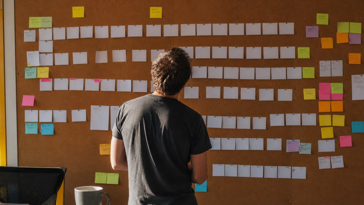 A planning desk with a storyboard grid of video thumbnail sketches and sticky notes grouping faceless channel ideas